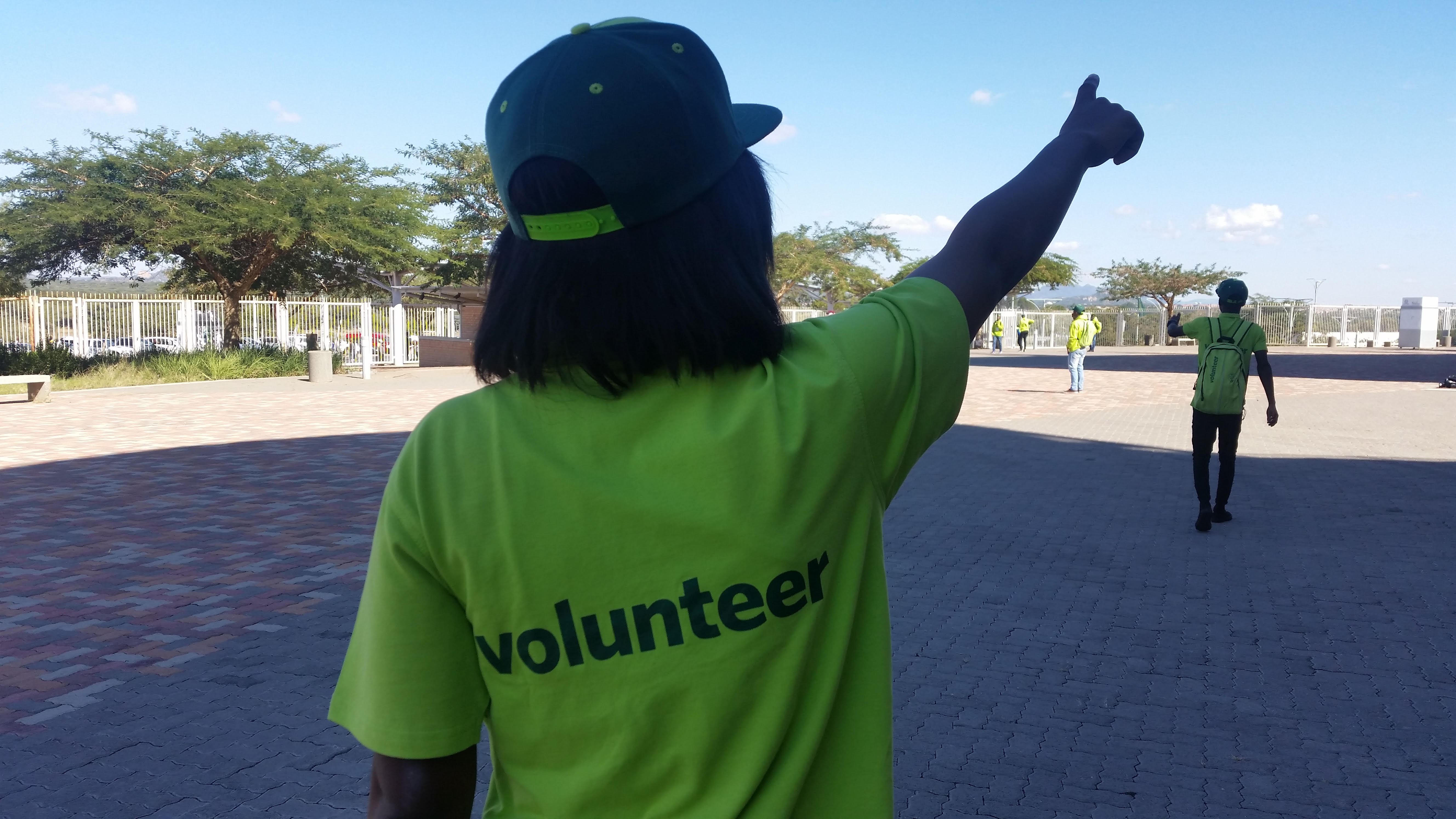 A Volunteer showing spectators where to go..